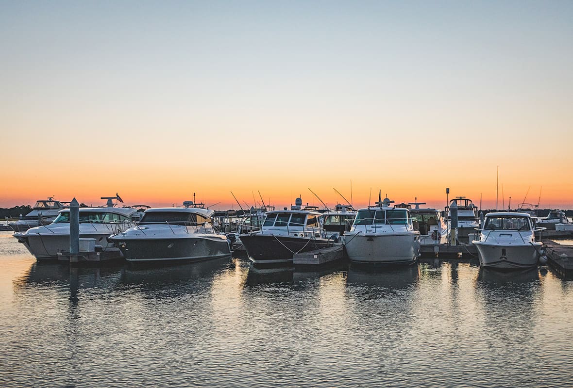 Boats docked at marina at sunset