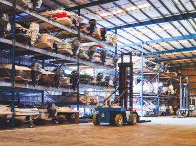 many boats on racks being stored in a warehouse