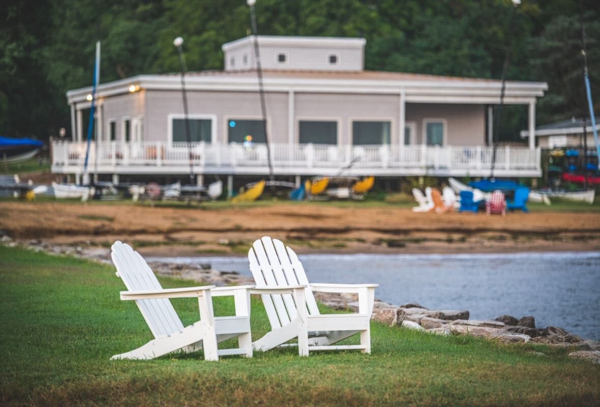 two white chairs on the shore