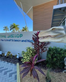 bishop museum sign with dinosaur statue