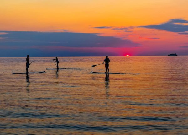 kayakers on water at sunset
