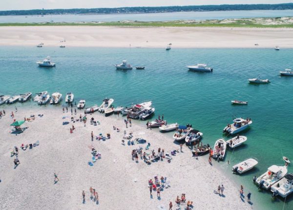 people and boats on sandy island