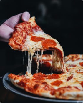 hand pulling slice of pepperoni pizza