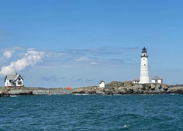 white lighthouse on a rocky shoreline