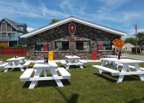 white picnic benches in front of an ice cream shop