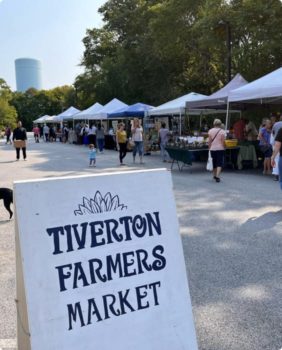 sign that says tiverton farmers market with the market in the background