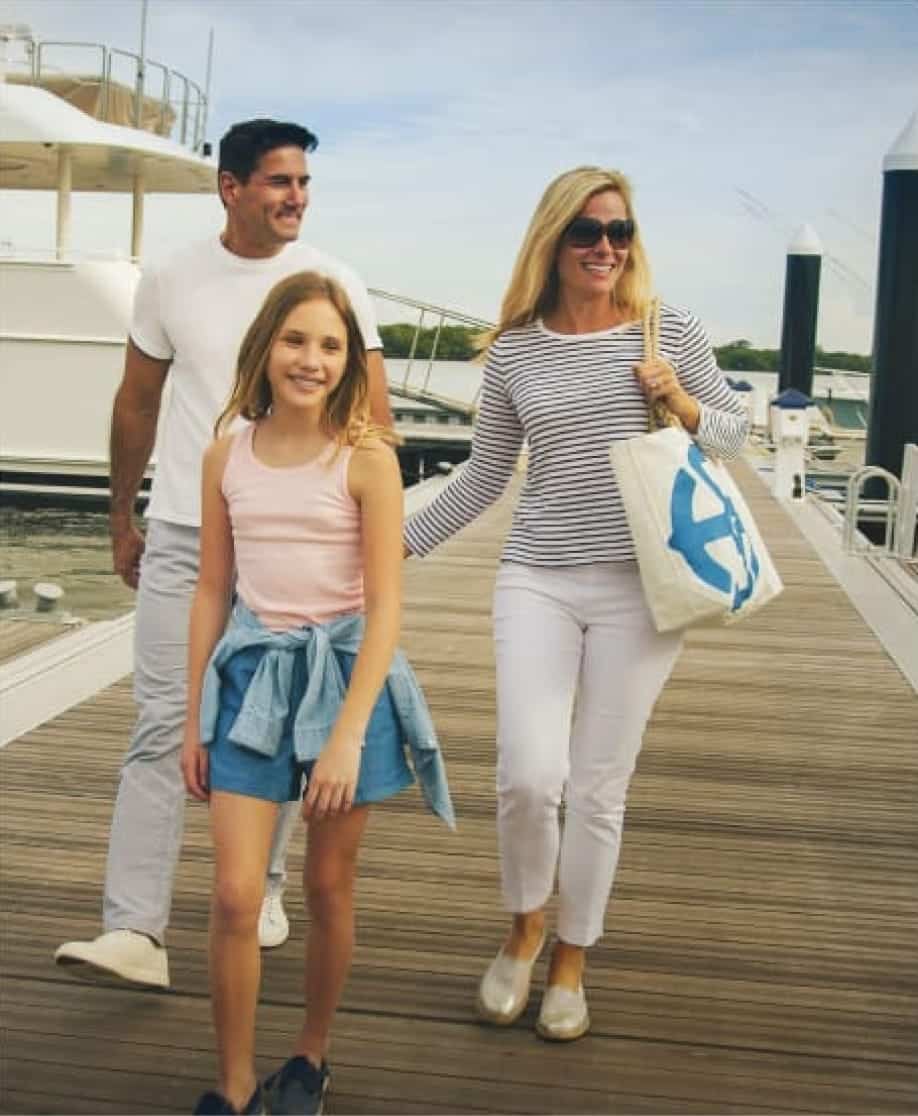 man woman and child walk on a boardwalk smiling