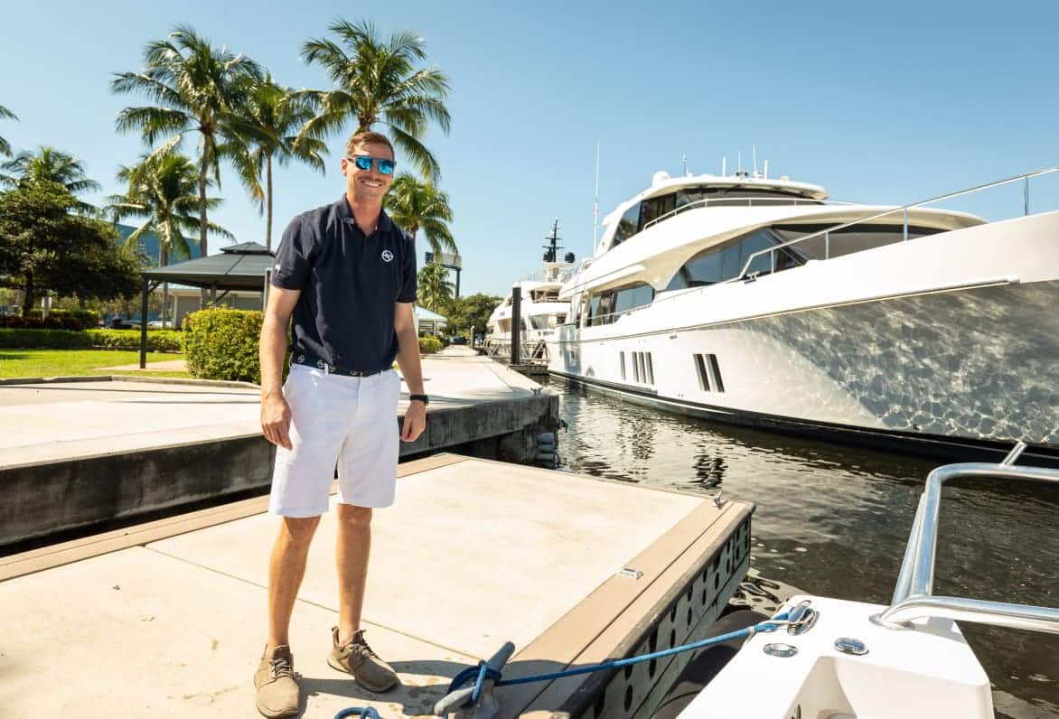 safe harbor employee standing on dock in front of yacht