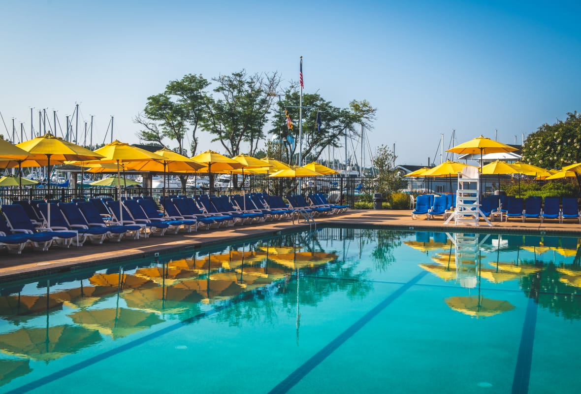 pool with blue chairs around it and yellow umbrellas