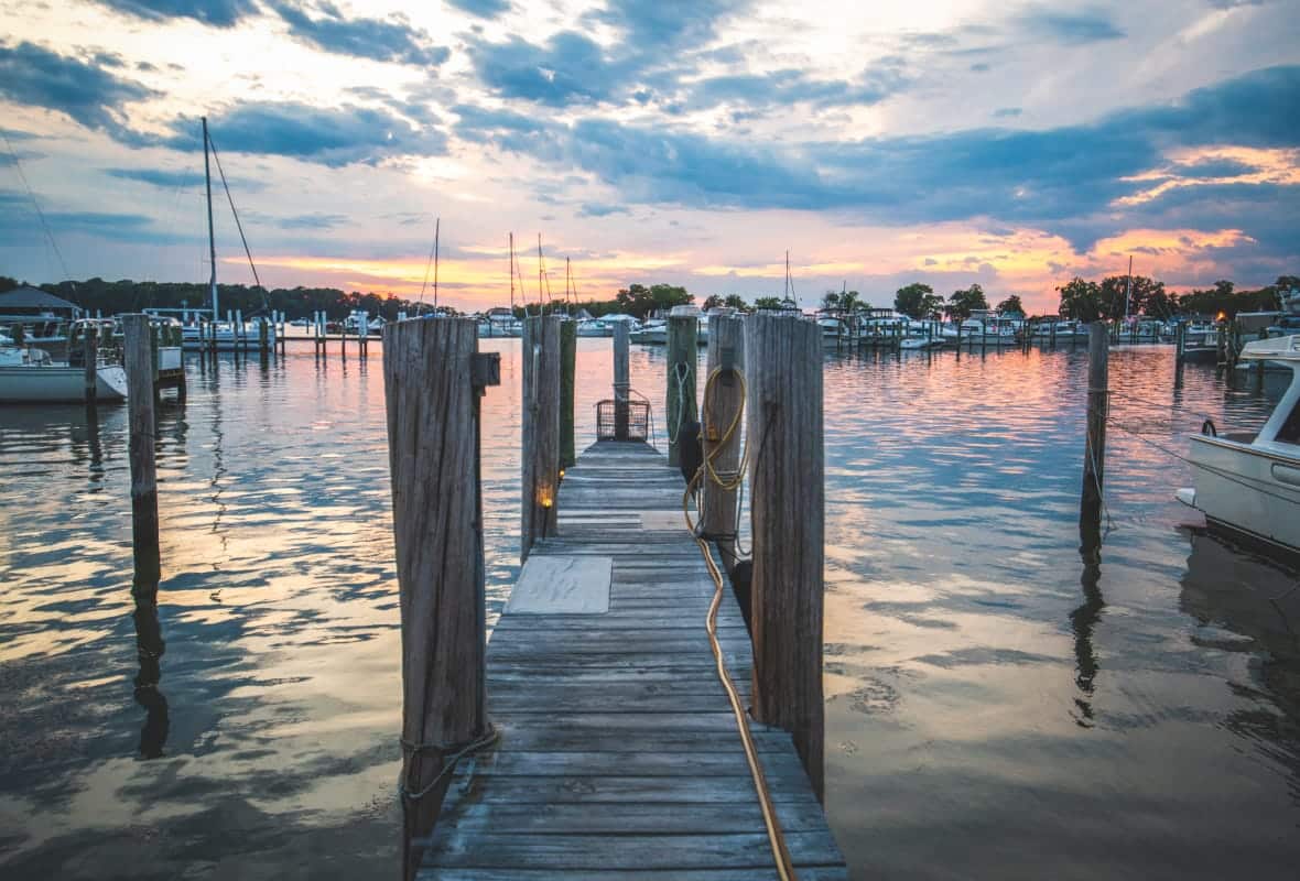 narrow dock path on the water with cloudy sunset