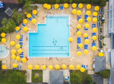 aerial view of pool with lots of yellow umbrellas surrounding it