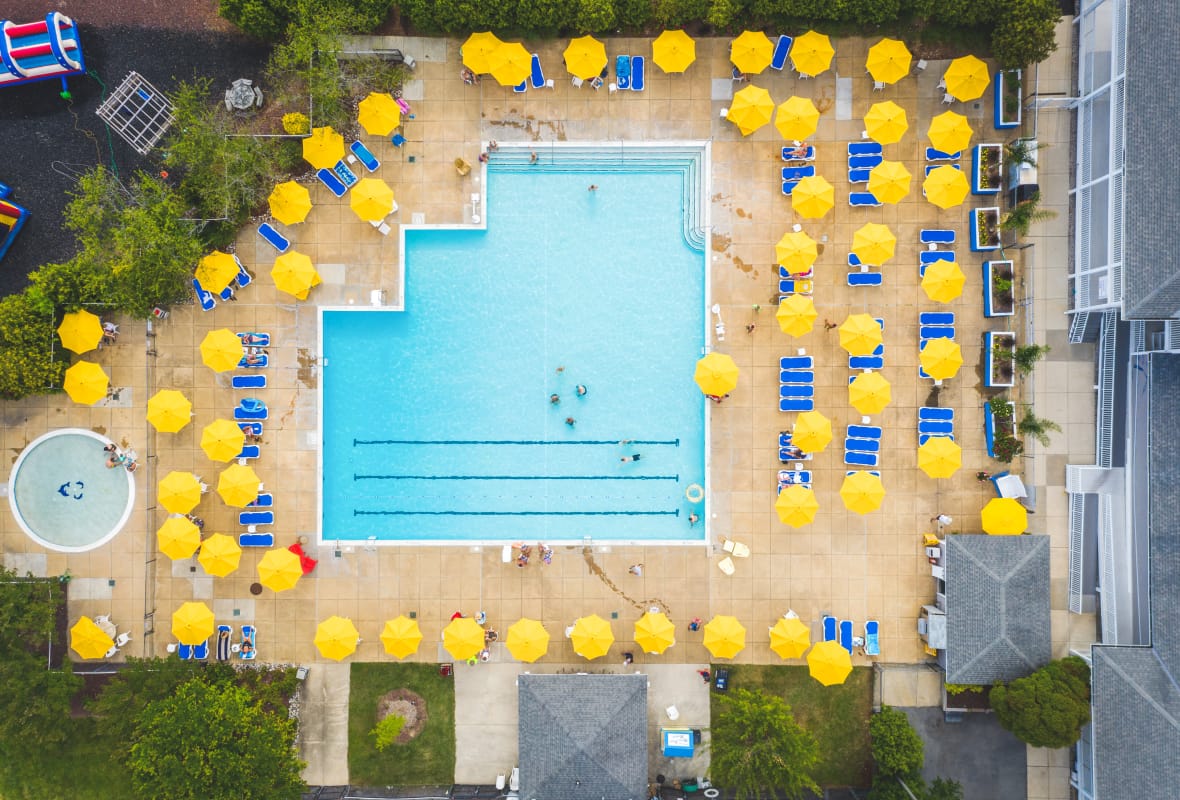 aerial view of pool with lots of yellow umbrellas surrounding it