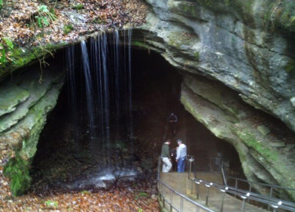 two people in a cave with waterfall