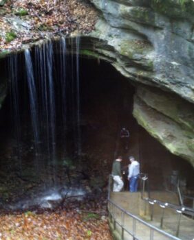 two men in a cave with water flowing over it