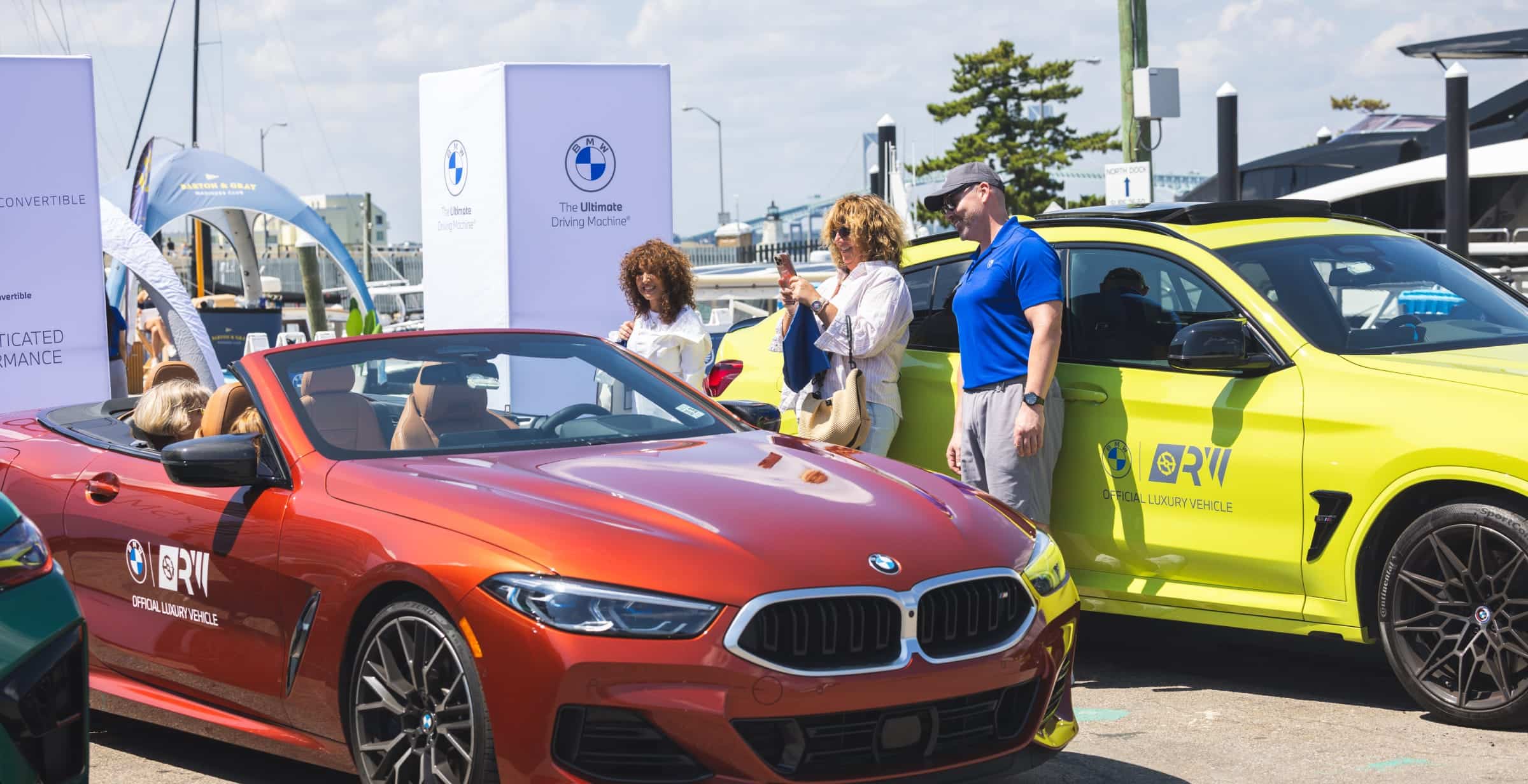 woman smiling taking a picture of a BMW car